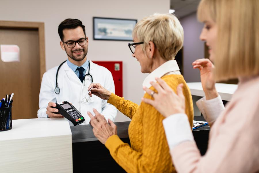 woman paying a bill for medical services at the hospital counter