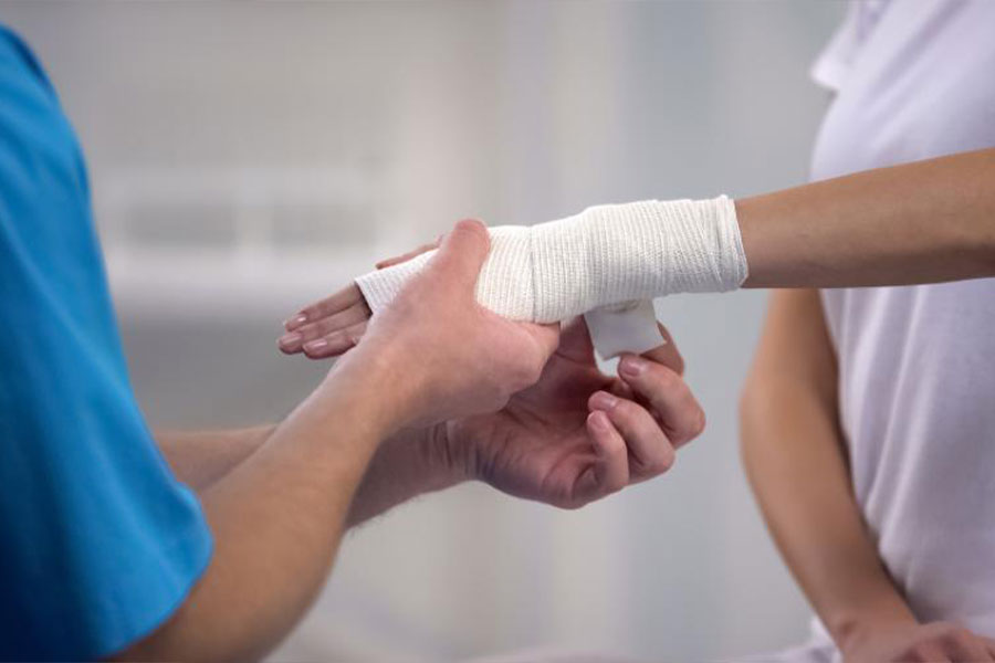 orthopedist applying wrist elastic wrap on female patient hand joint dislocation